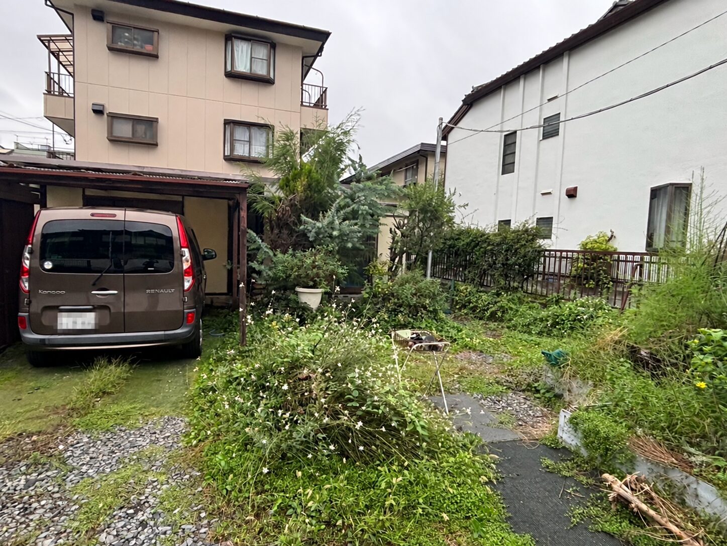 除草前 通路や砂利部分に雑草が広がる敷地